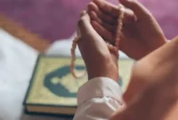 Seorang Muslim sedang berzikir dan berdoa sambil memegang tasbih di tangannya.